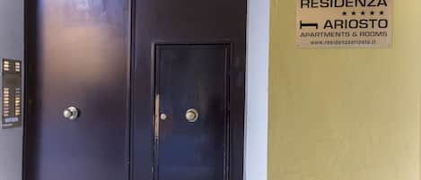 A dark elevator door with a keypad and a sign indicating room number 11.