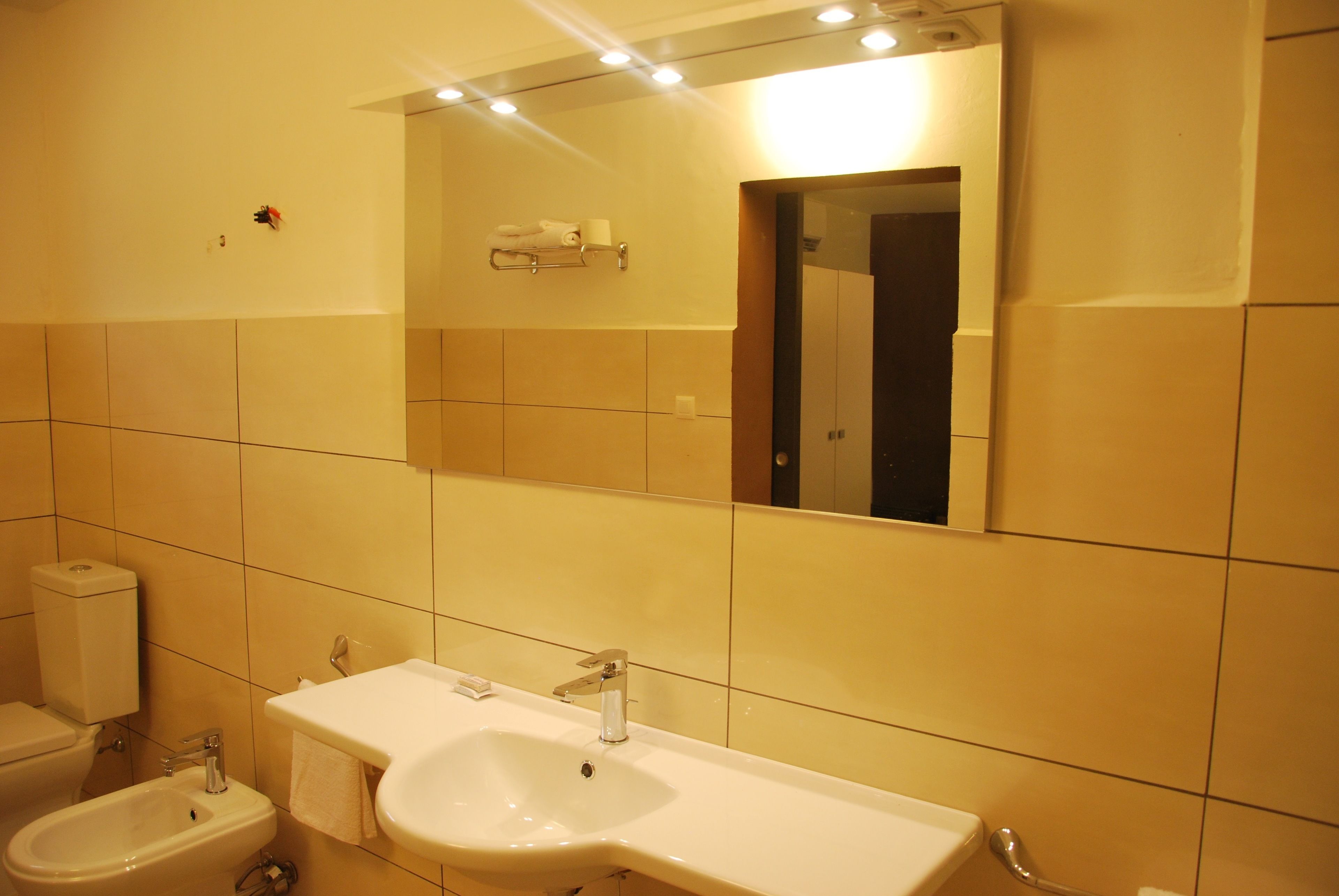 A bathroom with a sink, bidet, and toilet.