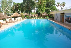 Outdoor pool, pool umbrellas, sun loungers - Hôtel Terminus (Niamey)