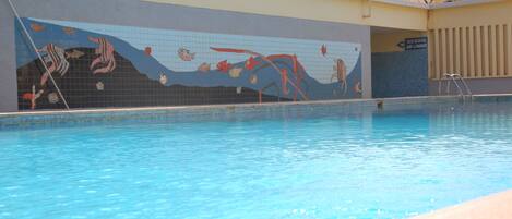 Una piscina con un mural de criaturas marinas en la pared.