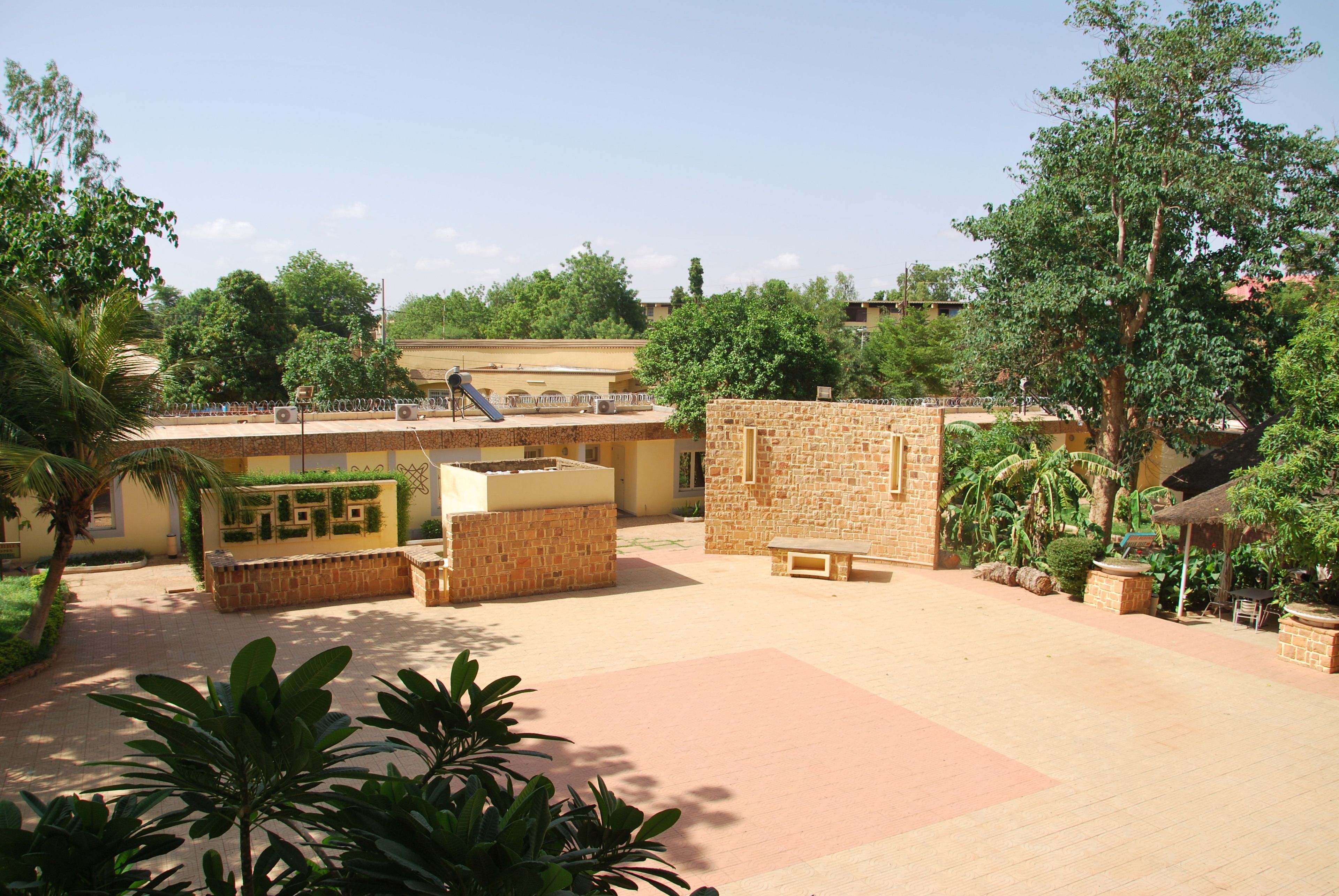 Une cour avec une piscine, des murs en pierre et de la verdure.