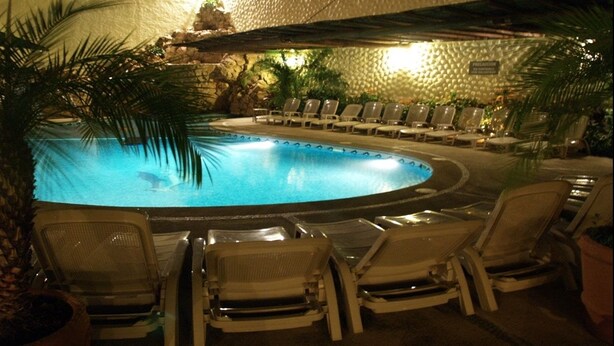 A pool area with lounge chairs and a tropical setting. - Hotel Argento (Cuernavaca)