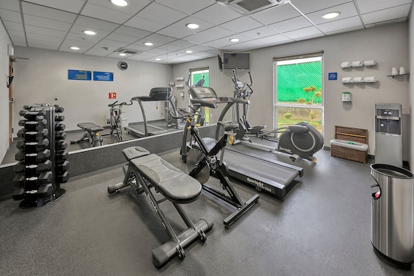 A gym with various exercise equipment including dumbbells, treadmills, and weight machines.