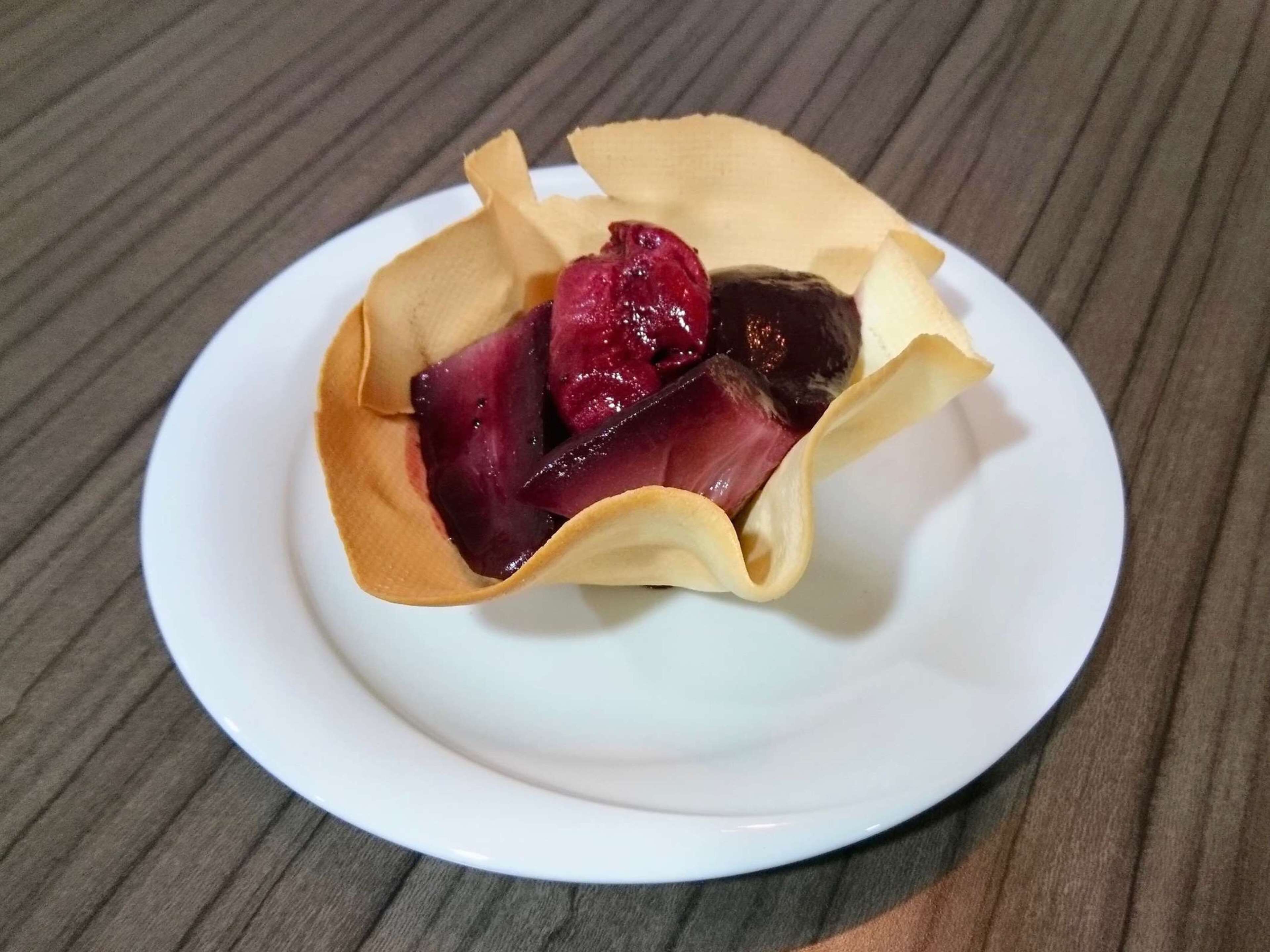 A dessert in a paper cup on a white plate.