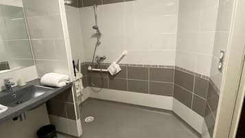 A modern bathroom with a corner shower, a sink with a mirror, and a towel rack.