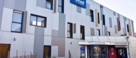 En modern hotellbyggnad med en reception och en restaurangdel.