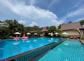 Una piscina al aire libre, sombrillas, tumbonas