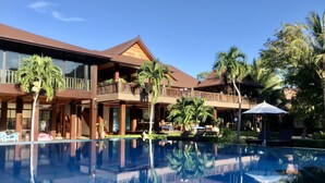 A resort with a large pool, wooden balconies, and palm trees. - Phi Phi Villa Resort (Ko Phi Phi)