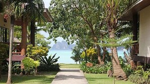 A pathway leading to a building with a view of the ocean and mountains. - Phi Phi Villa Resort (Ko Phi Phi)