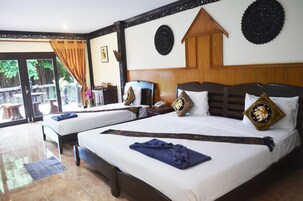 Habitación de hotel con dos camas, un cabecero de madera y un ventanal con vistas al exterior.