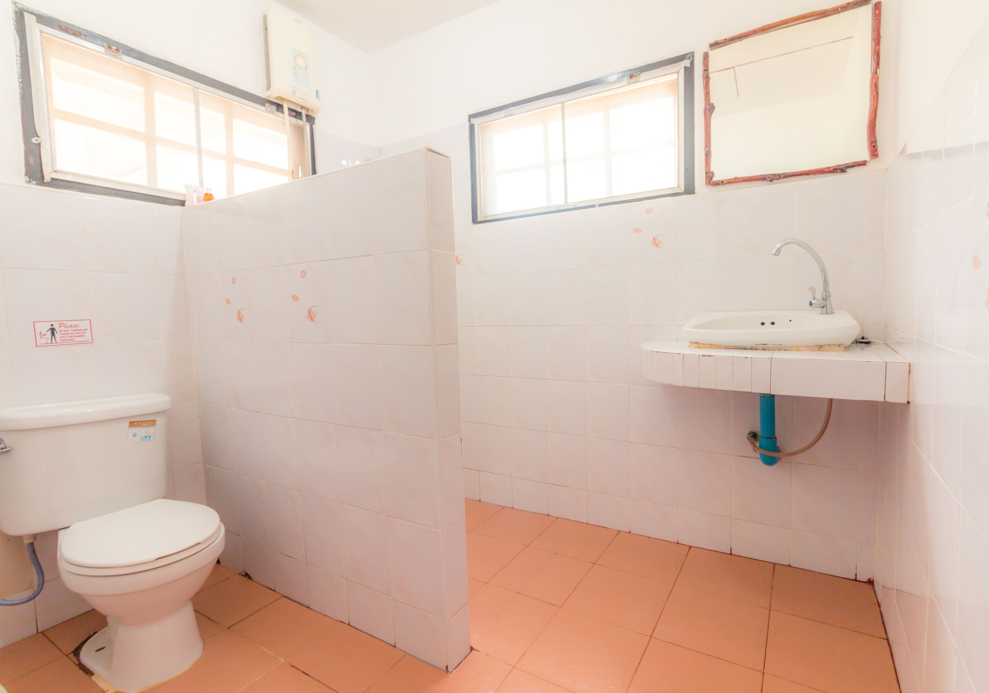A bathroom with a toilet, sink, and tiled walls.