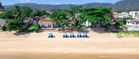 En la playa, playa de arena blanca y camastros
