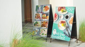 Dos carteles exteriores de menú que anuncian 'All Day Breakfast' y ofertas especiales por 250 Baht.