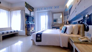 Una camera d'albergo con un letto, una scrivania con il telefono, una panca e un'ampia finestra.