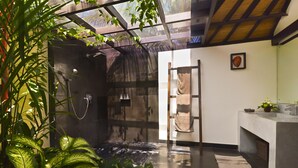 A modern bathroom with a glass-enclosed shower, a wooden ladder, and a sink area with a towel rack. - Elok Villas (Seminyak)
