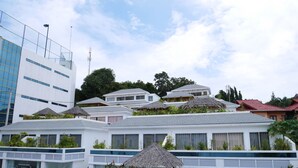 Ein Hotel mit mehreren weißen Gebäuden, einer Rezeption und Sitzgelegenheiten im Freien mit Sonnenschirmen.