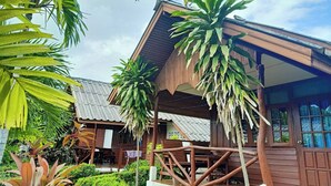 A wooden house with a porch, surrounded by tropical plants. - Palm Point Village (Koh Samui)
