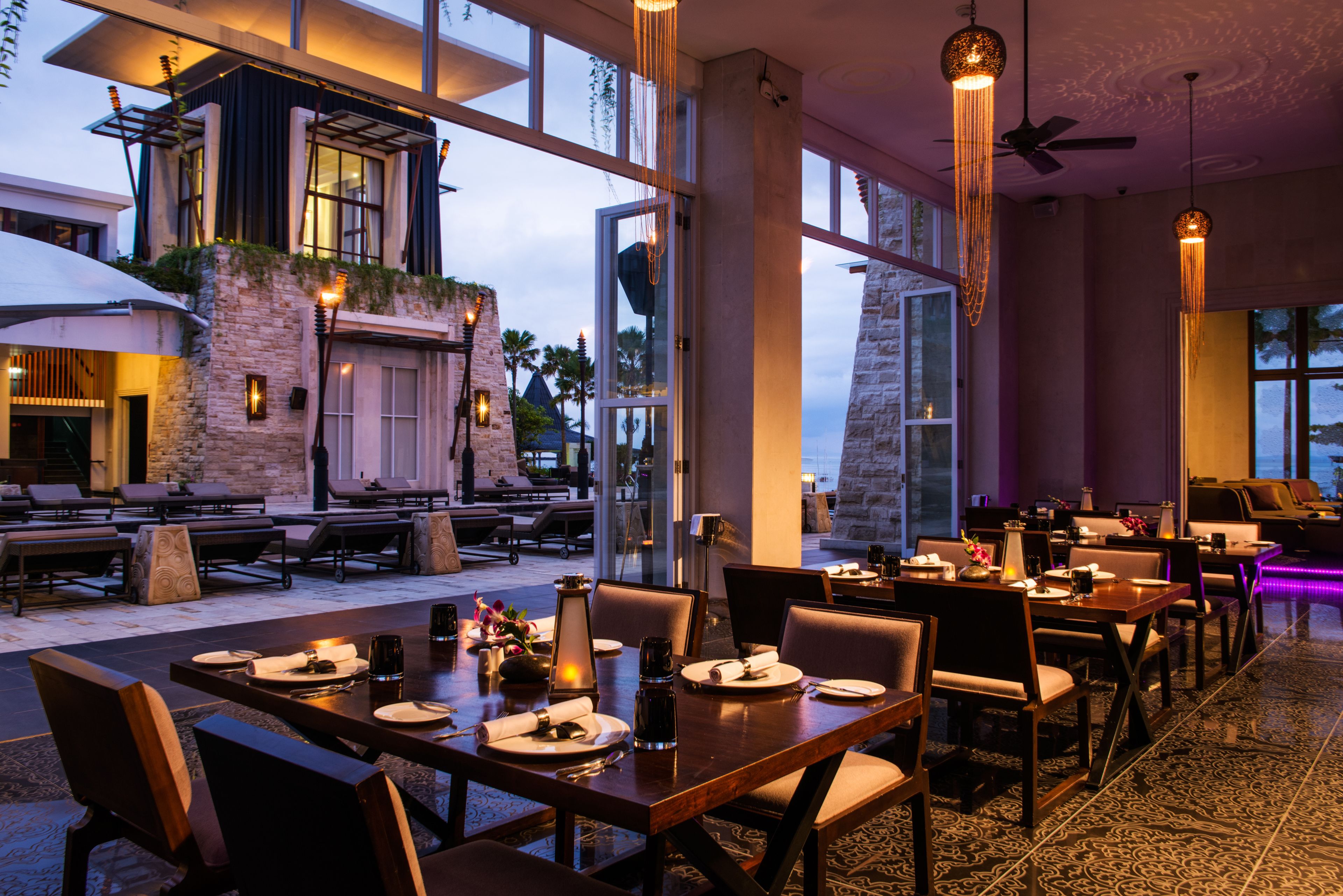 A restaurant with outdoor seating, large windows, and modern interior design.
