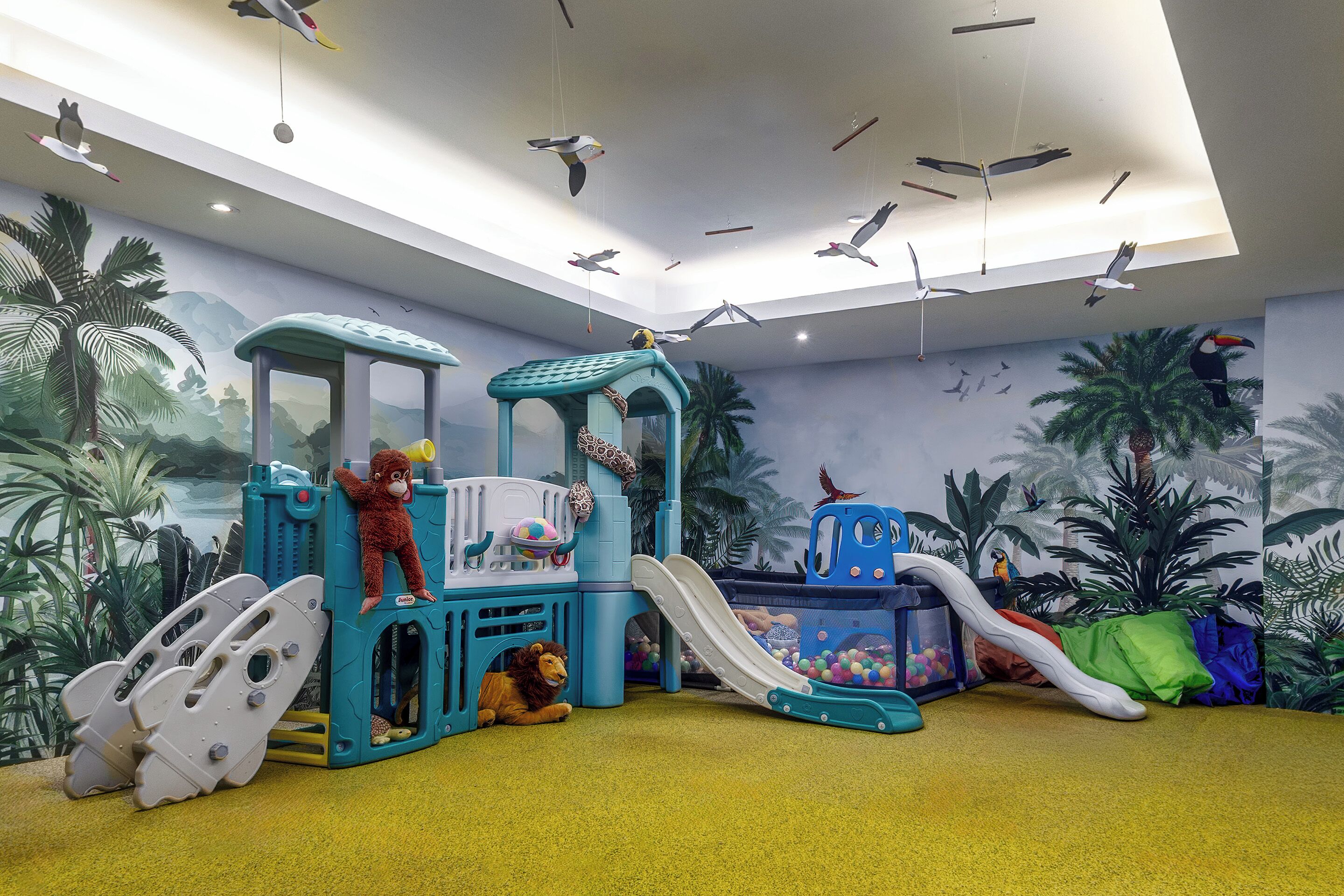 Ein Kinderspielbereich mit Rutschen, Klettergerüsten und einem Ballbecken.