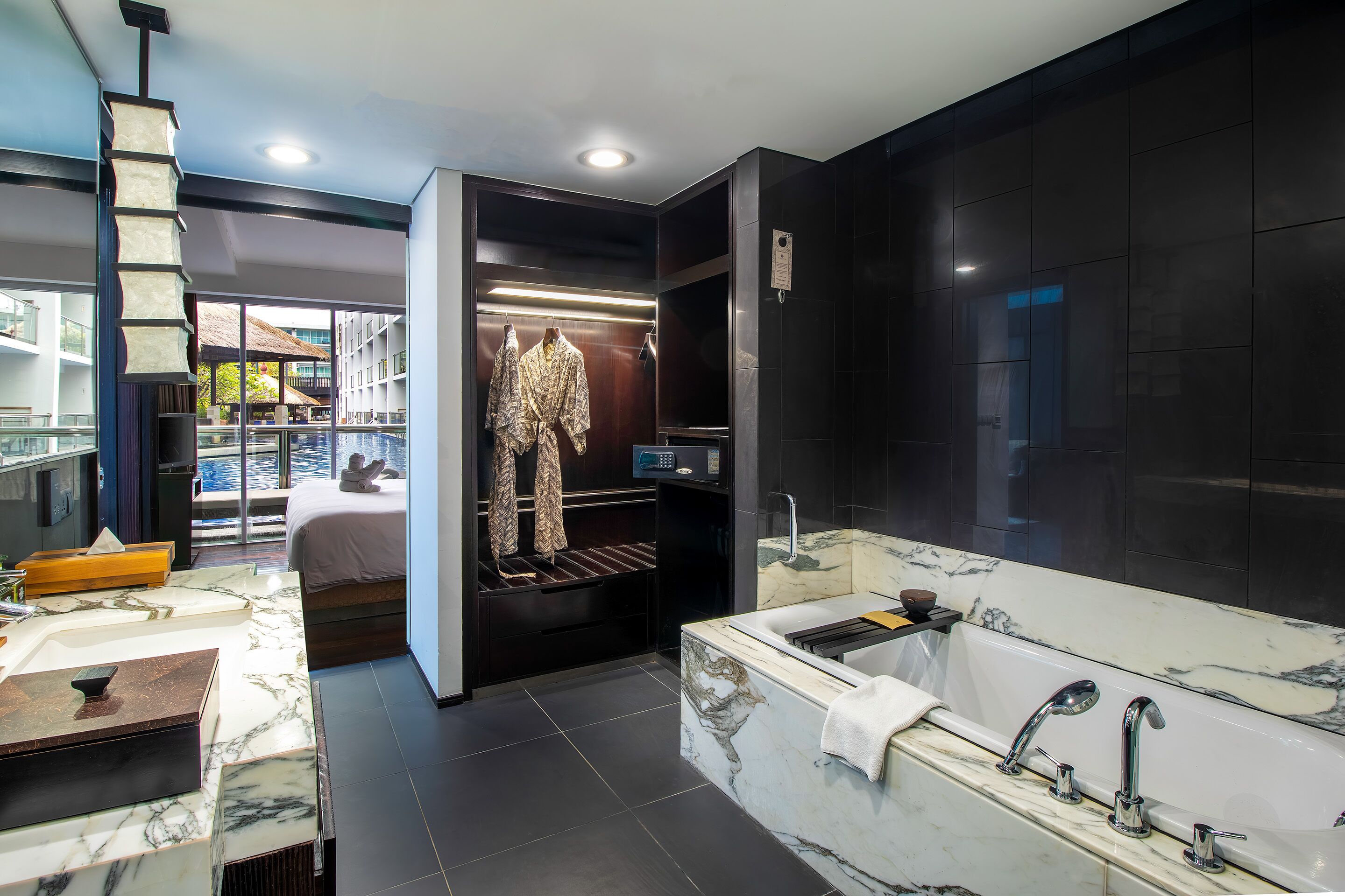 A modern bathroom with a large marble sink, a freestanding bathtub, and a walk-in shower.