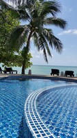 Una piscina al aire libre, sillones reclinables de piscina