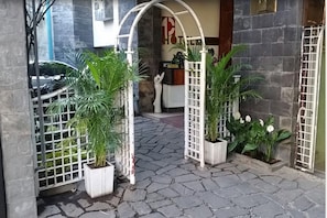 A hotel entrance with a stone-paved pathway leading to a reception area.