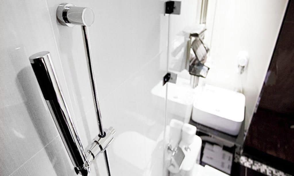 A bathroom with a toilet, a sink, and a mirror.