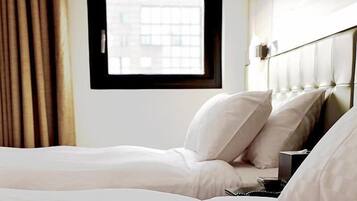 A hotel room with a bed, a window, and curtains.