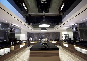 Una cocina moderna con una isla central, iluminación suspendida y un salpicadero de mármol.