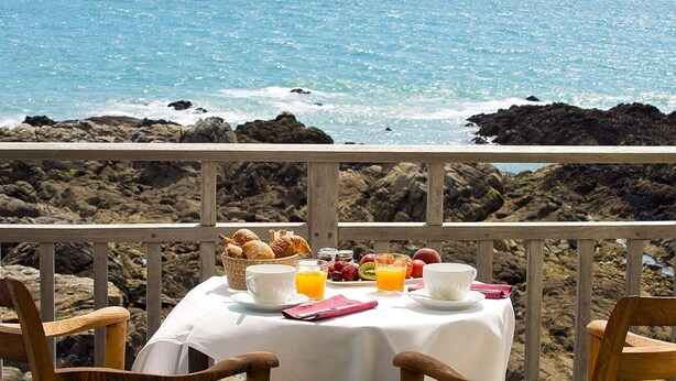 A table set with breakfast items and a view of the ocean. - Hôtel de L'Océan (Le Croisic)