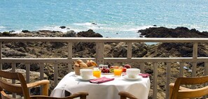A table set with breakfast items and a view of the ocean. - Hôtel de L'Océan (Le Croisic)