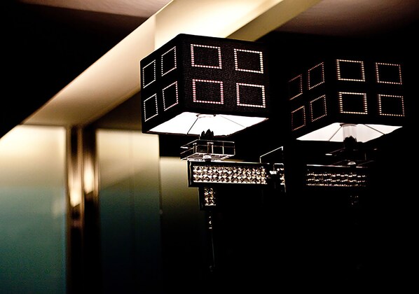 Two illuminated cube-shaped light fixtures with a grid pattern, mounted on a wall.