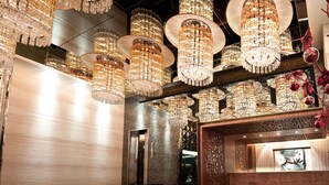 Un intérieur luxueux agrémenté de plusieurs lustres, d’un mur en bois et d’un panneau de verre décoratif.