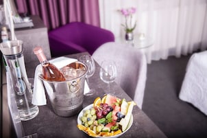 Ein Esstisch mit einer Champagnerflasche, Eiswürfeln und einer Obstplatte.