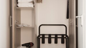 Un vestidor con estantes, una barra para colgar ropa y una caja fuerte.
