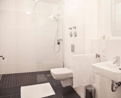 Un baño moderno con ducha, inodoro y lavamanos.