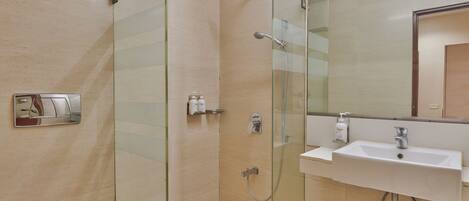 A modern bathroom with a glass-enclosed shower, a white sink, and a toilet.