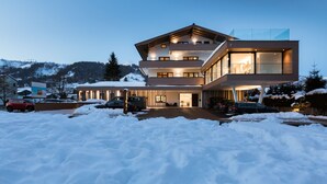 A modern two-story house with a glass balcony, surrounded by snow. - die Bergerin - Appartements Schladming (Schladming)
