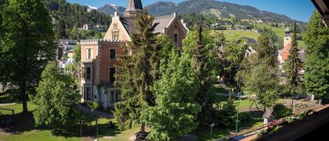 A view of a town with a prominent church, a playground, and surrounding greenery.