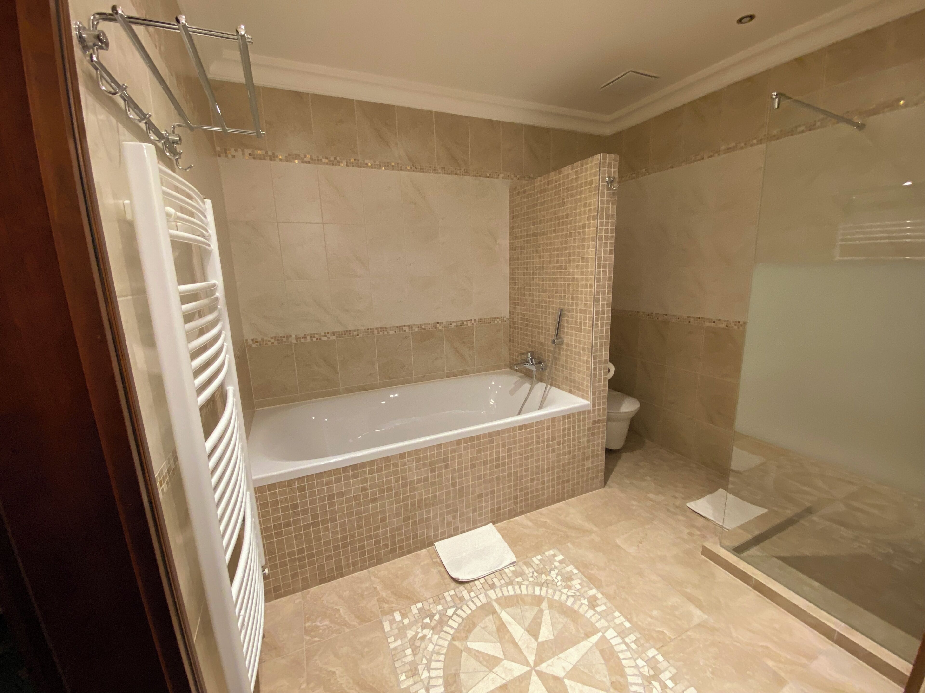 Ein modernes Badezimmer mit einer freistehenden Badewanne, einer gläsernen Dusche und einem WC.