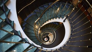 A spiral staircase with a central column and handrails.