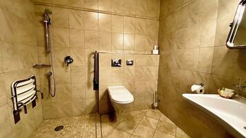 A bathroom with a shower, toilet, and sink, all with modern fixtures.