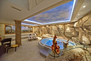 A spa area with a hot tub, seating, and a mural of a landscape.