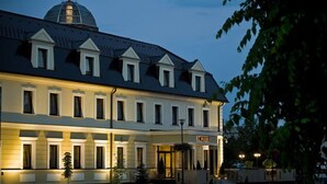 A hotel with a symmetrical facade, a central entrance, and a dome on the roof.