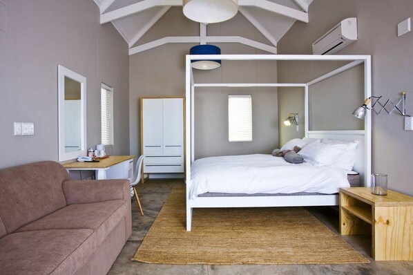 Un dormitorio moderno con una litera, un escritorio, una silla y un sofá.
