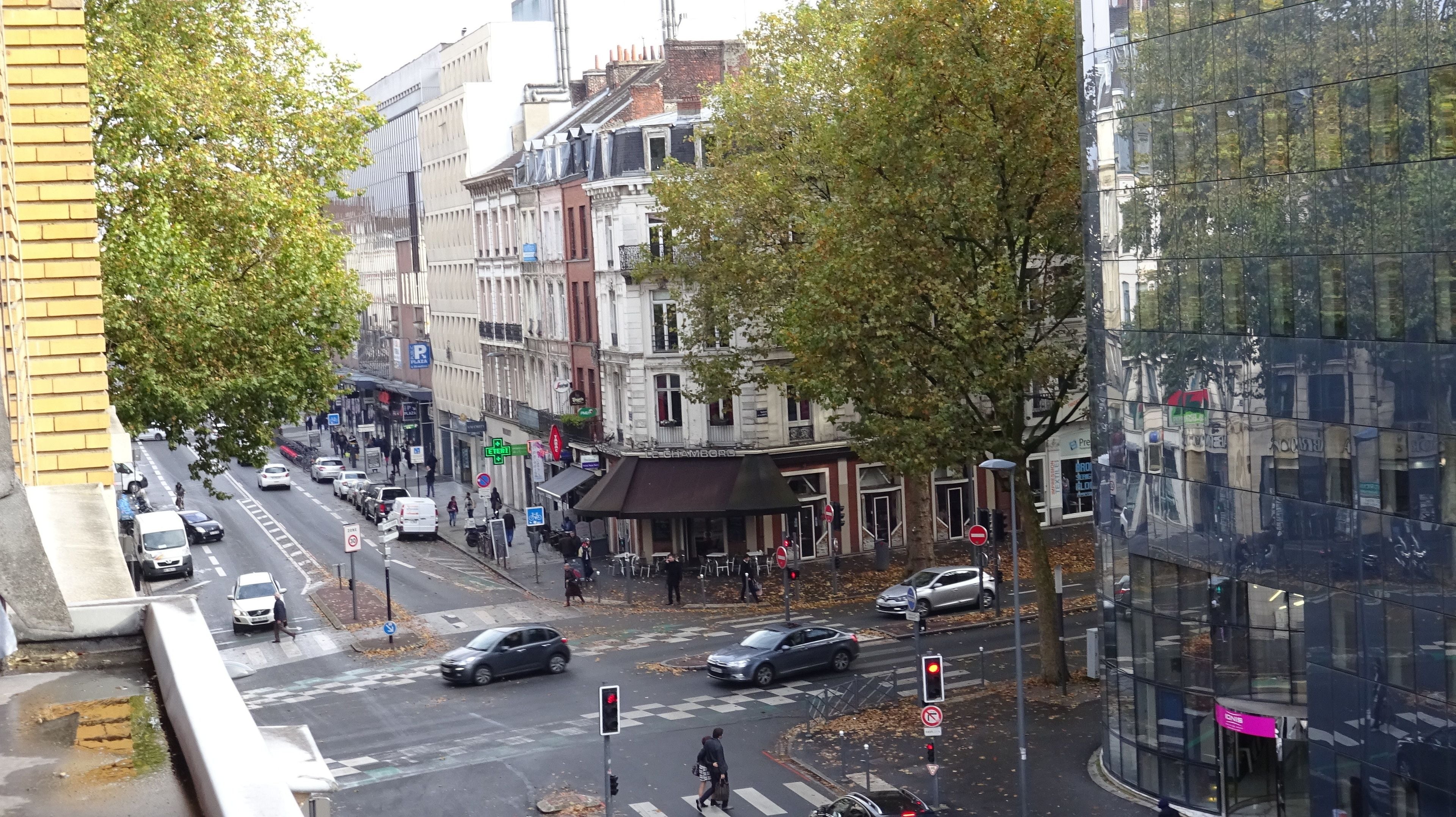 A street view with buildings, cars, and pedestrians.