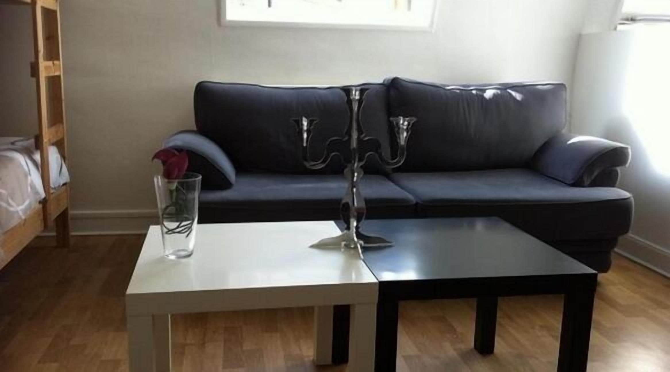 A living room with a dark grey sofa, a white coffee table, and a candelabra.