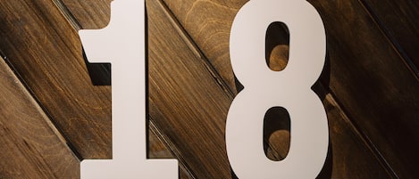 Un piso de madera con grandes números blancos '18' y '52' y la palabra 'THE' sobre ellos.