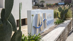 A sign for 'Hotel Adriatico' with a clear view of the building's architecture in the background. - Hotel Adriatico (Tricase)