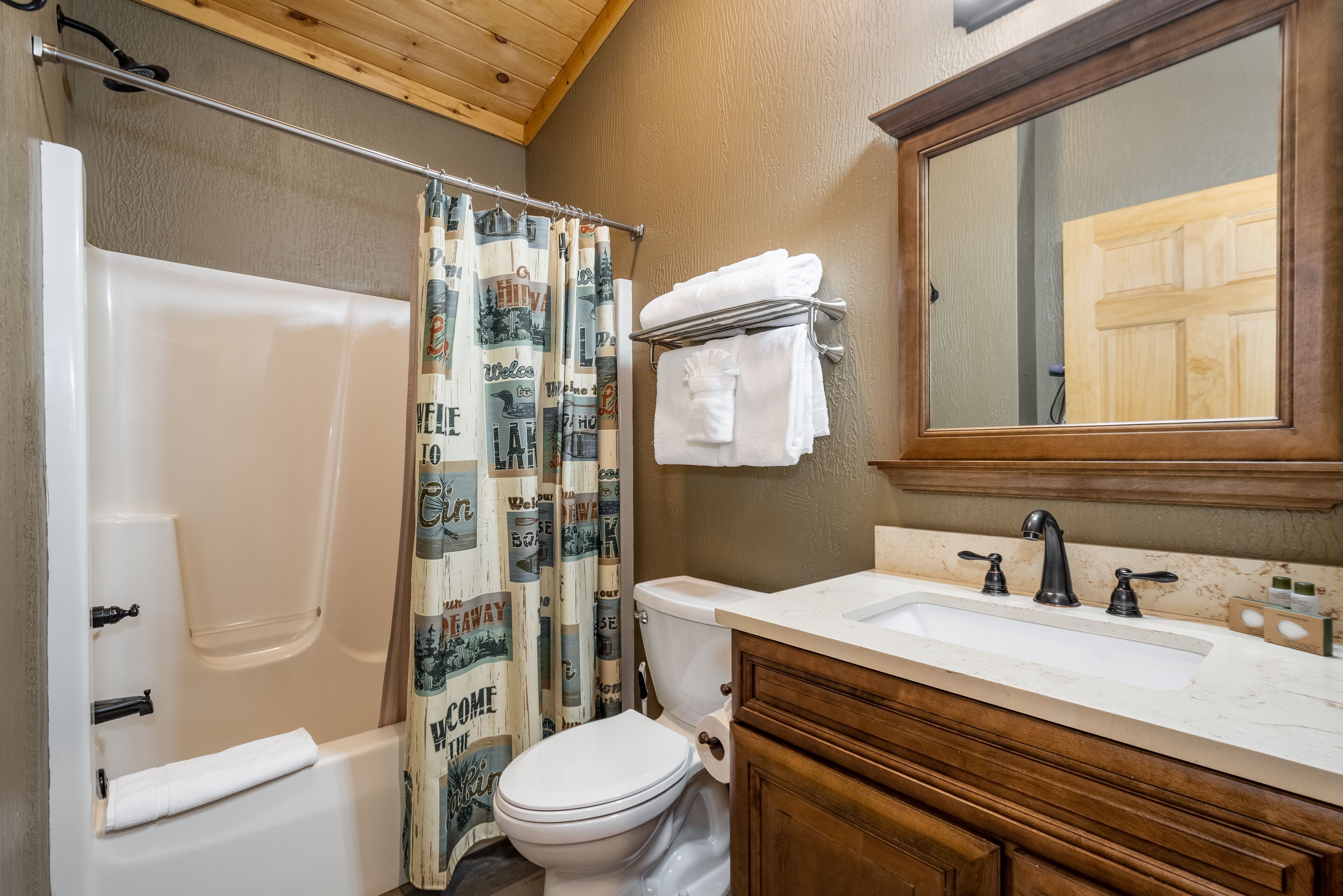 A bathroom with a bathtub, toilet, and sink.